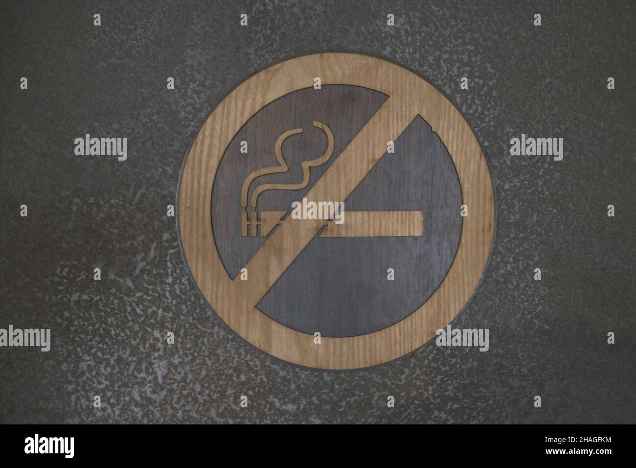 No smoking cigarette sign in on the wall in cafe. wooden sign on the dark grey wall. Prohibited signs to be placed inside buildings Stock Photo