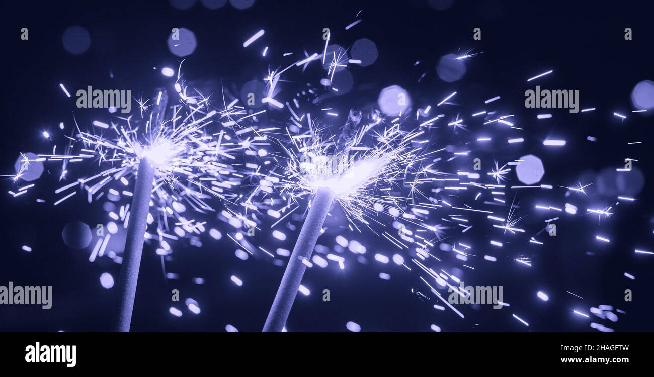 Bright glittering sparkler on blurred bokeh background Stock Photo