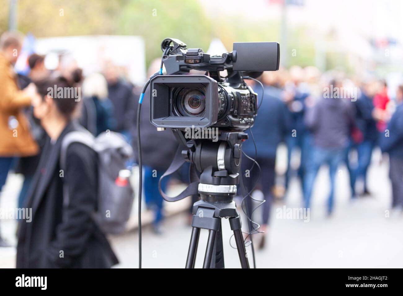 TV camera lens in the focus, blurred people in the background Stock