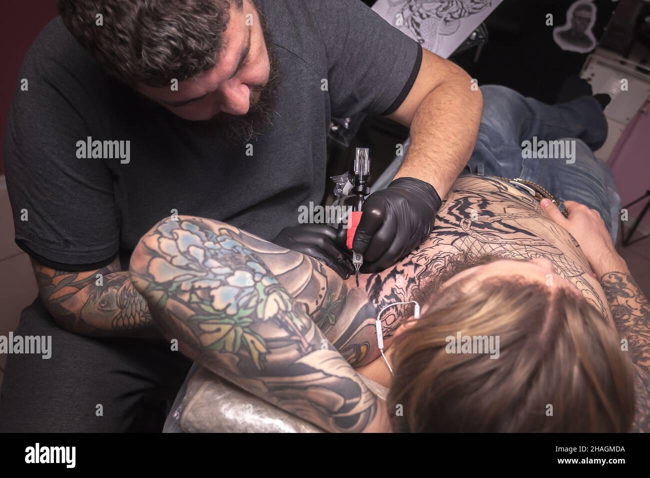 Professional tattooer making tattoo art in his salon Stock Photo