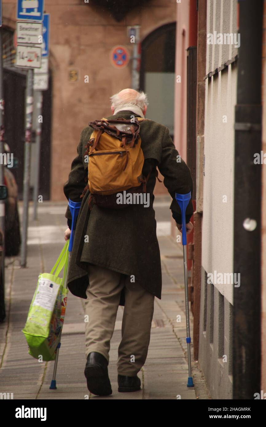 Back view of of a senior man with walking sticks in the street Stock ...