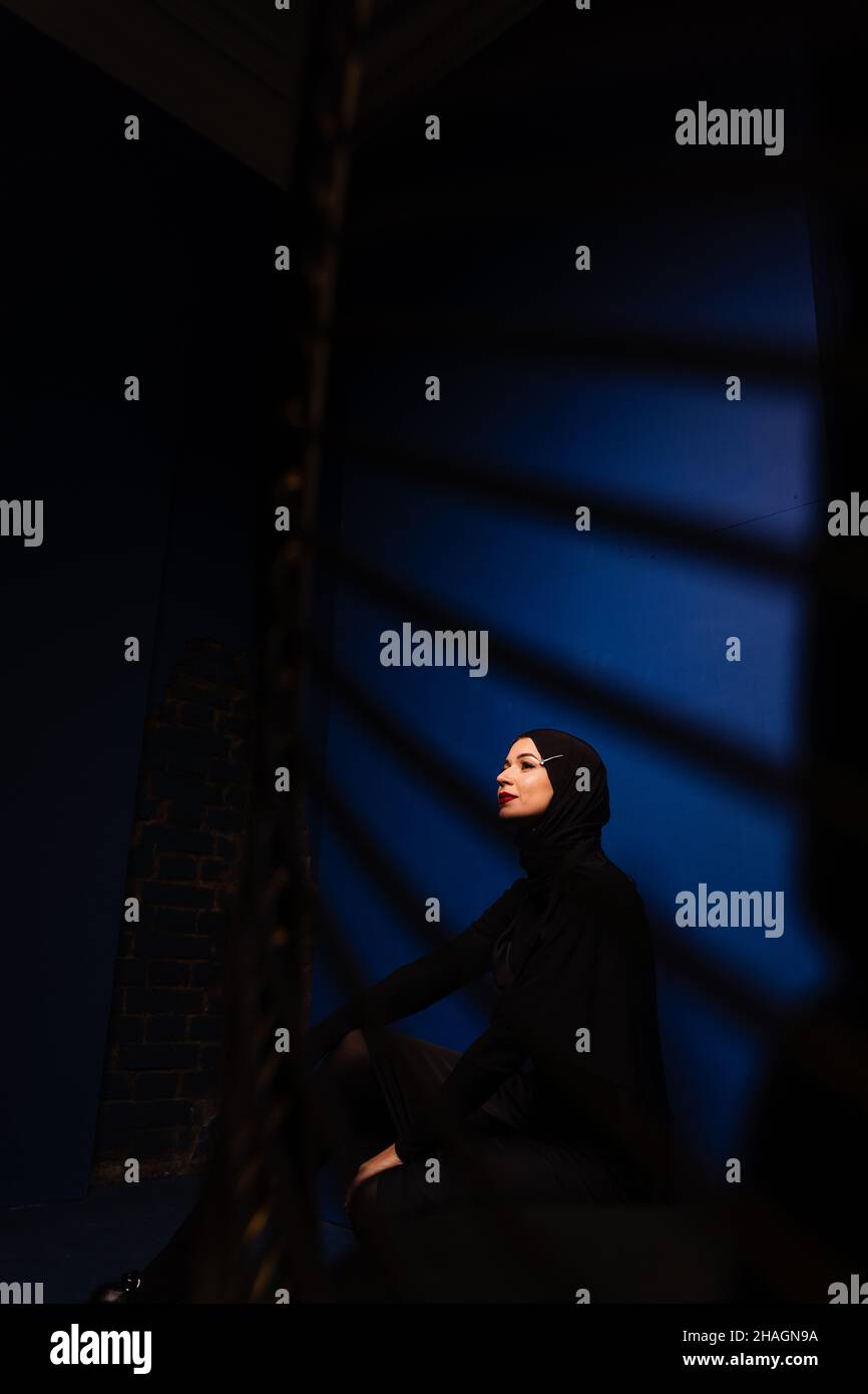 Fashion muslim model in black hijab is posing on blue background in ...