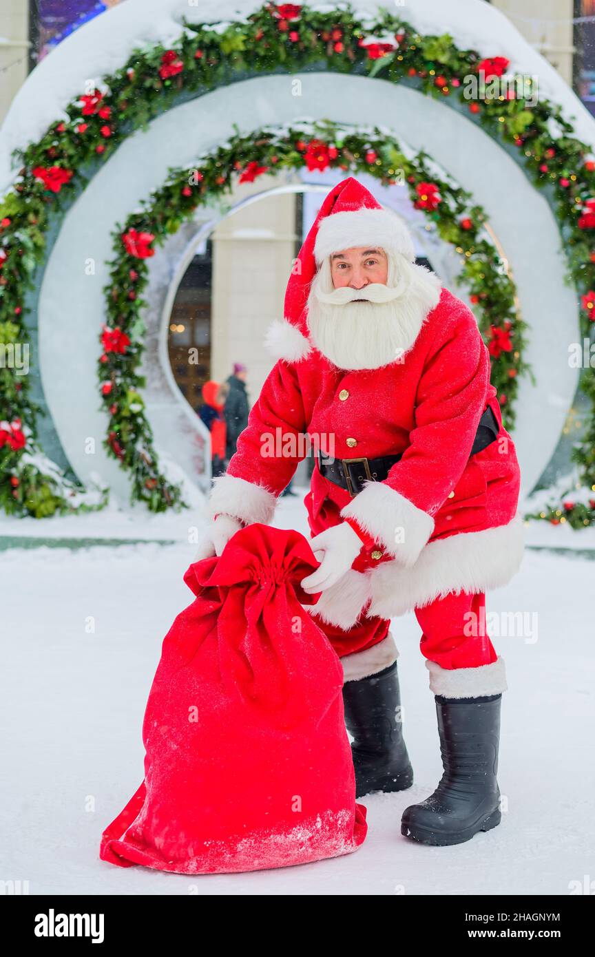Santa Claus posing with a bag of gifts on the background of Christmas ...