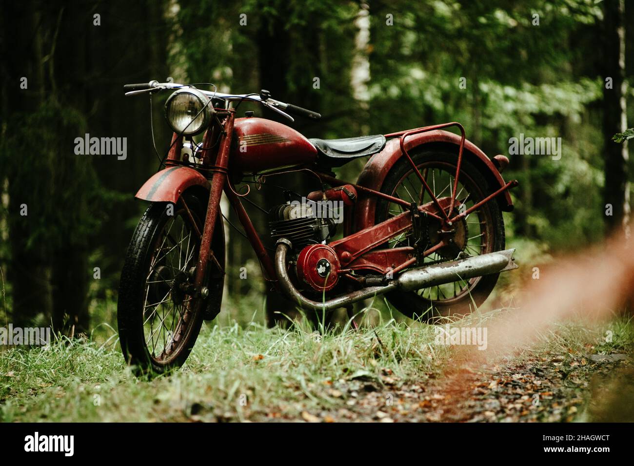 1951s red motorcycle parked in a forest Stock Photo - Alamy