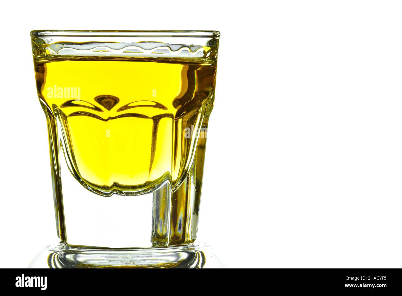On a white background on the left side of a glass with whiskey closeup