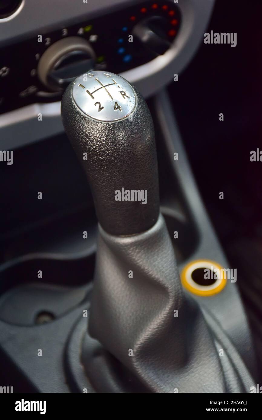 The handle of a car manual transmission with engraved numbers and a handle movement pattern. The background is very blurred Stock Photo