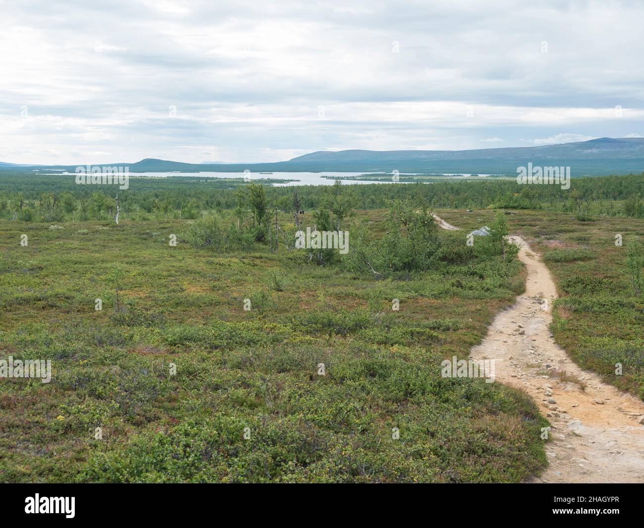Lapland landscape with beautiful river Lulealven, snow capped mountain, birch tree and footpath of Kungsleden hiking trail near Saltoluokta, north of Stock Photo