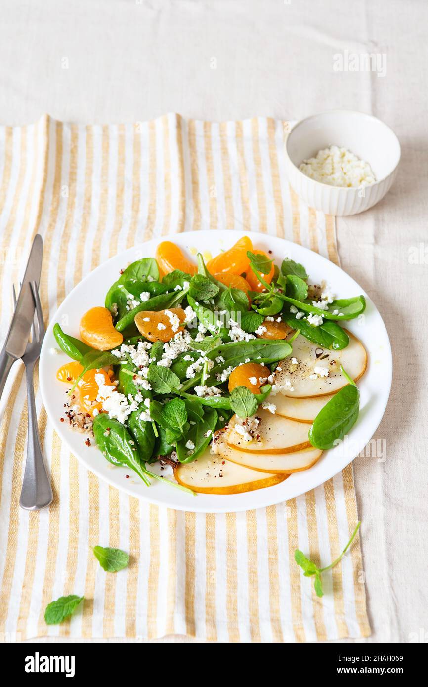 Spinach and quinoa salad with pears, oranges and ricotta. Healthy Meal