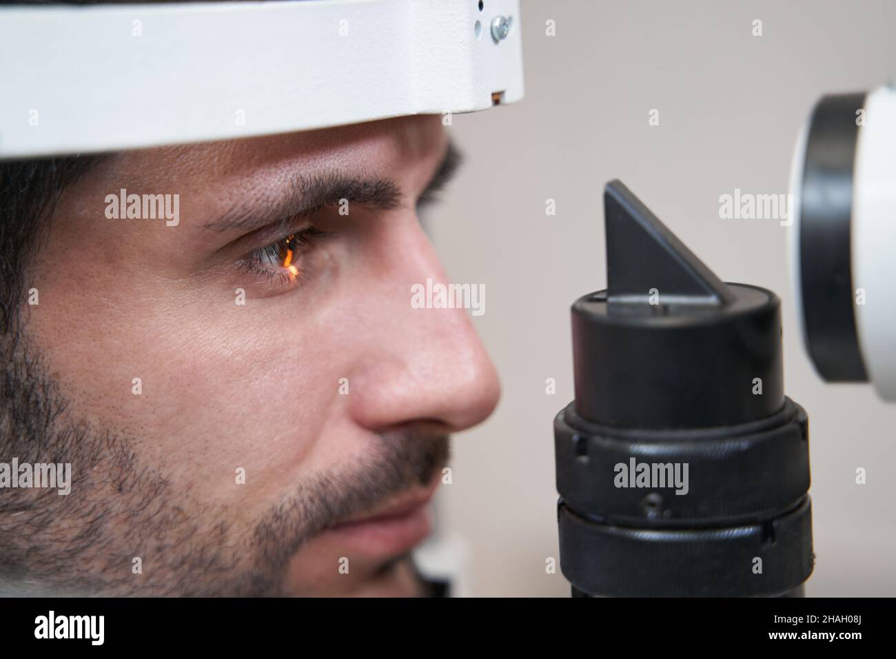 Man staring at light of slit lamp during eye inspection Stock Photo Alamy