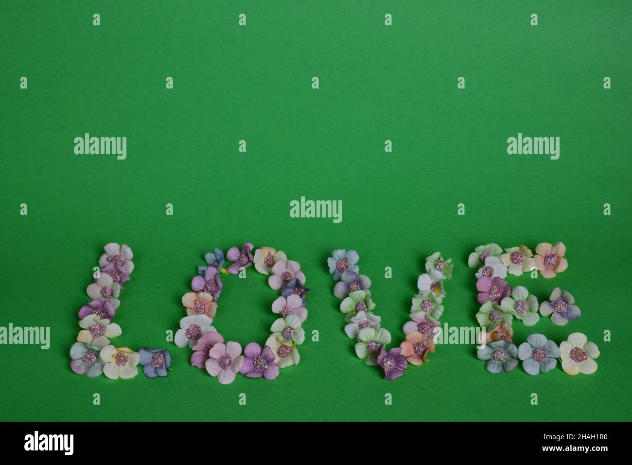 The word LOVE is lined with letters on a clean green background with