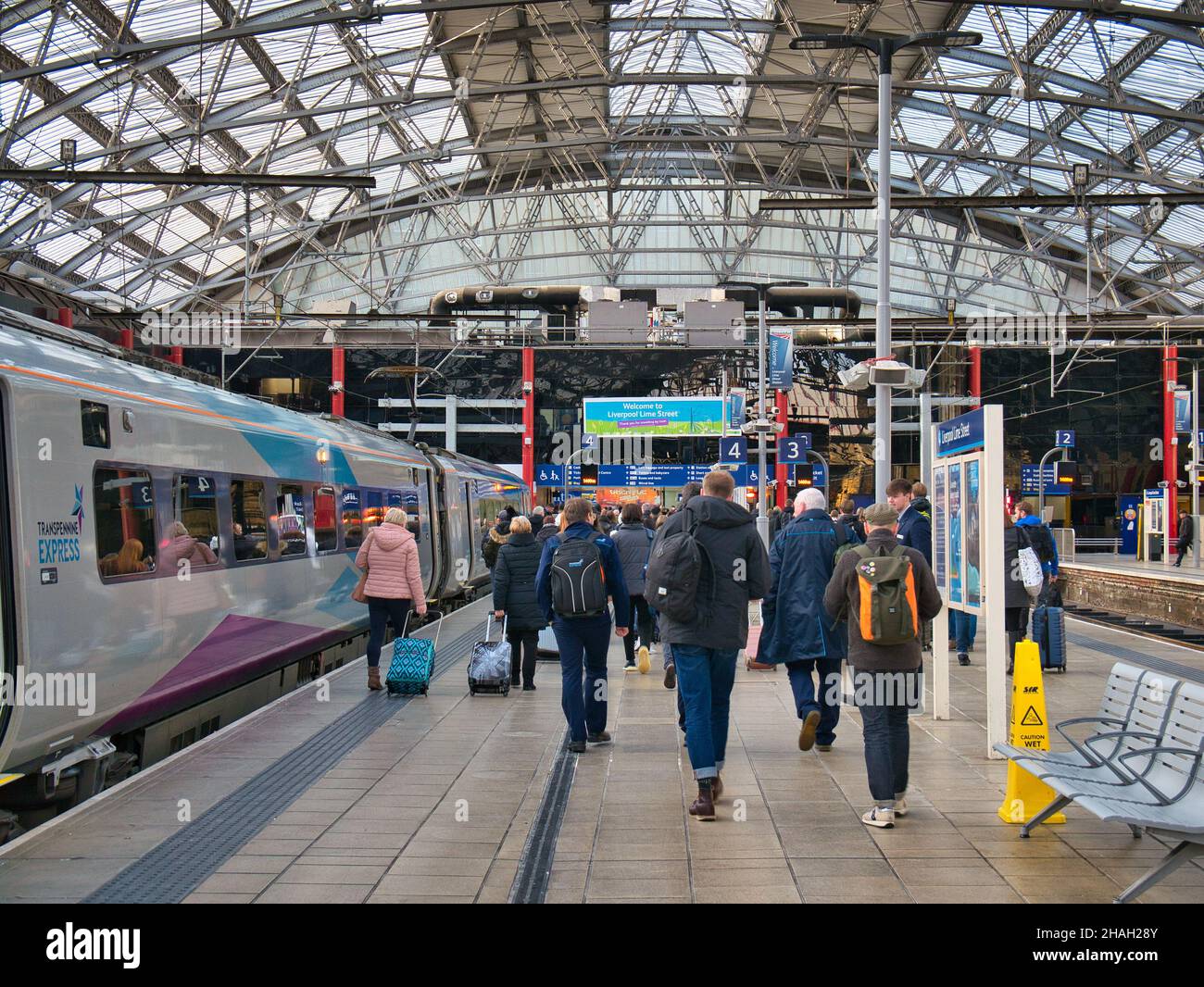 Passengers walk along the station platform after leaving the TransPennine Express train from Newcastle at Lime Street Station in Liverpool, UK Stock Photo