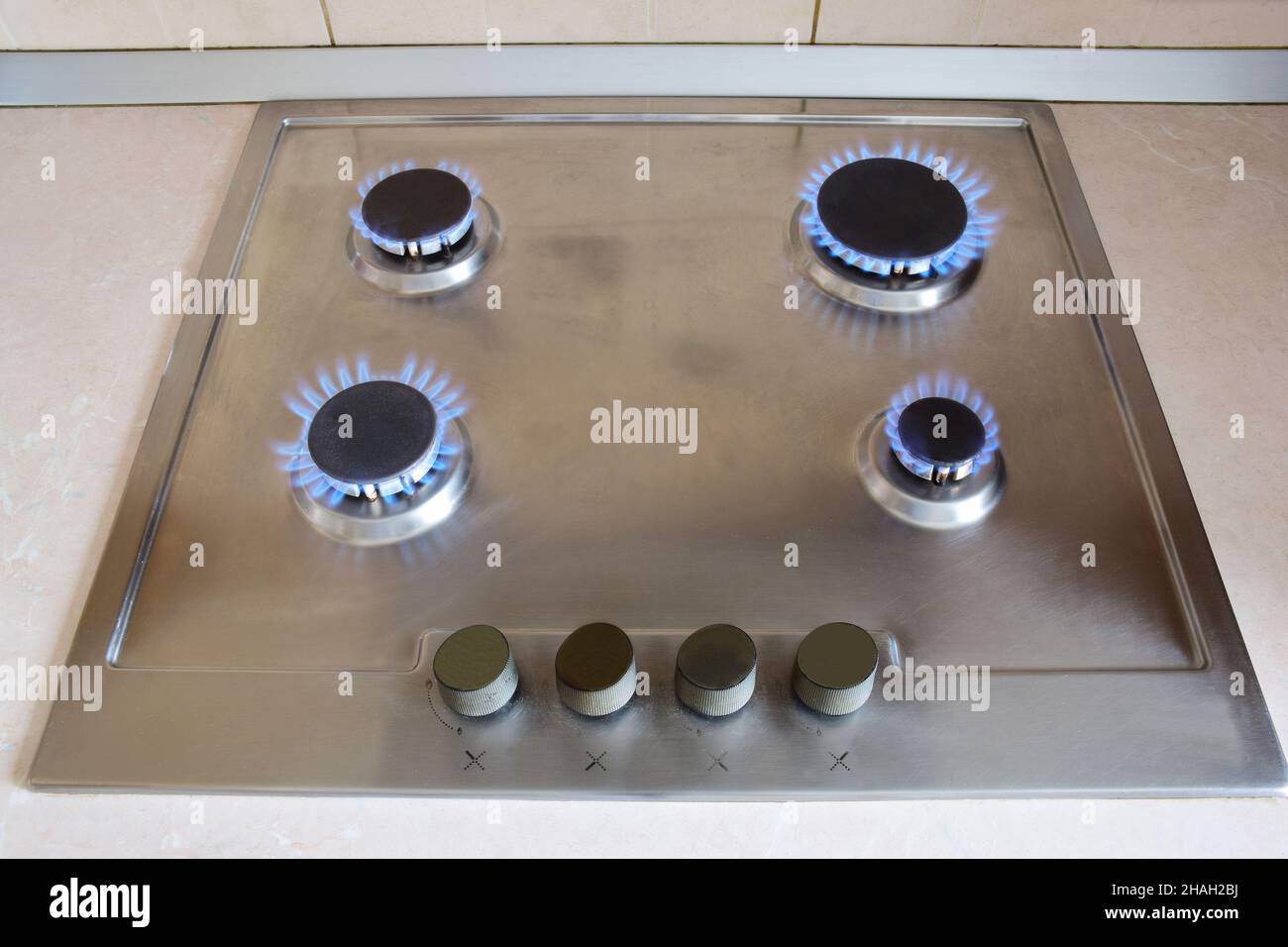 Kitchen gas stove with four redhot burners burning blue flame Stock