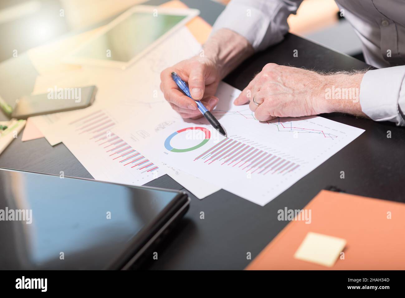 Businessman analyzing graphics at office, light effect Stock Photo - Alamy