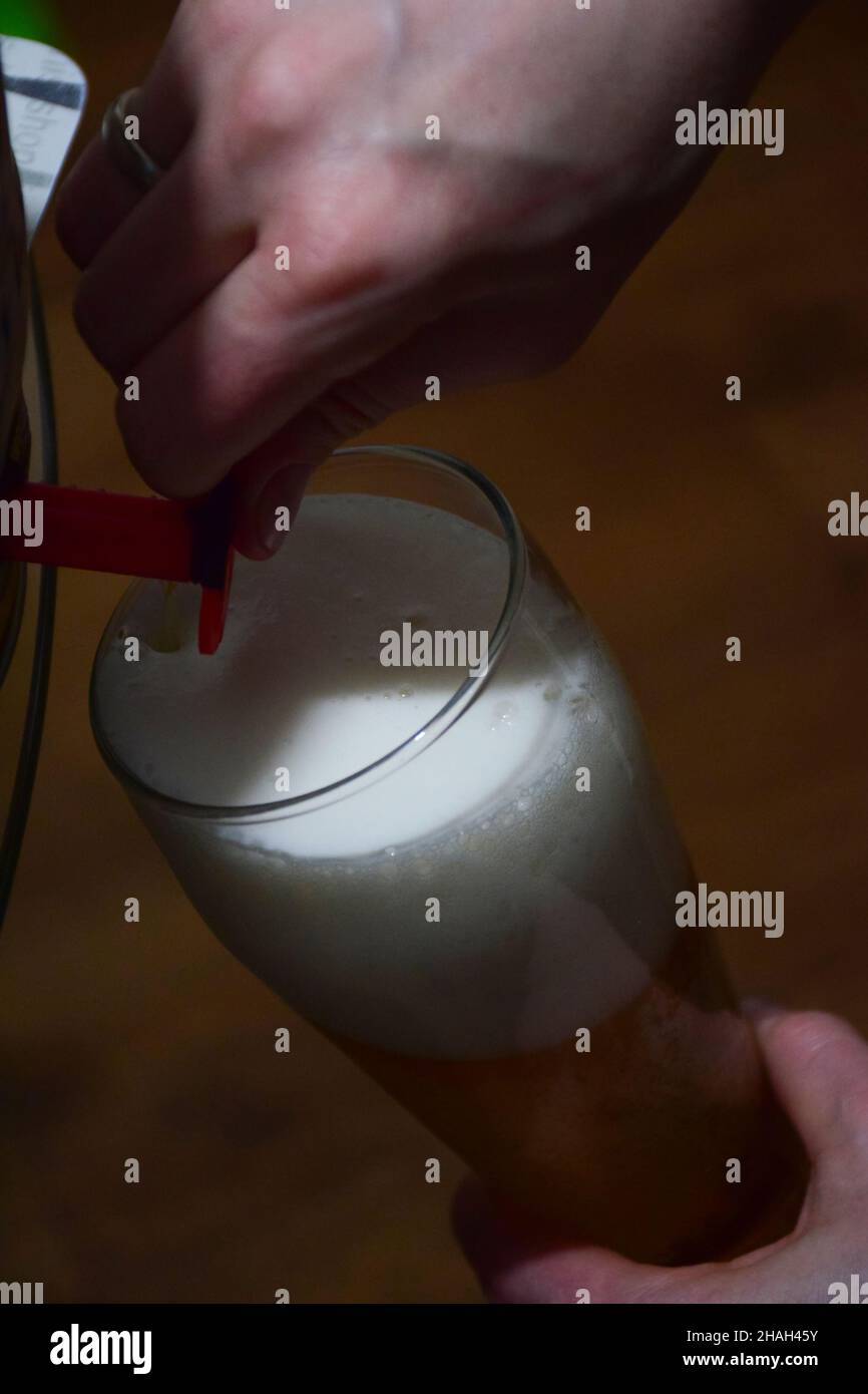 Foamy beer is poured from a beer barrel through a tap into a glass goblet Stock Photo Alamy