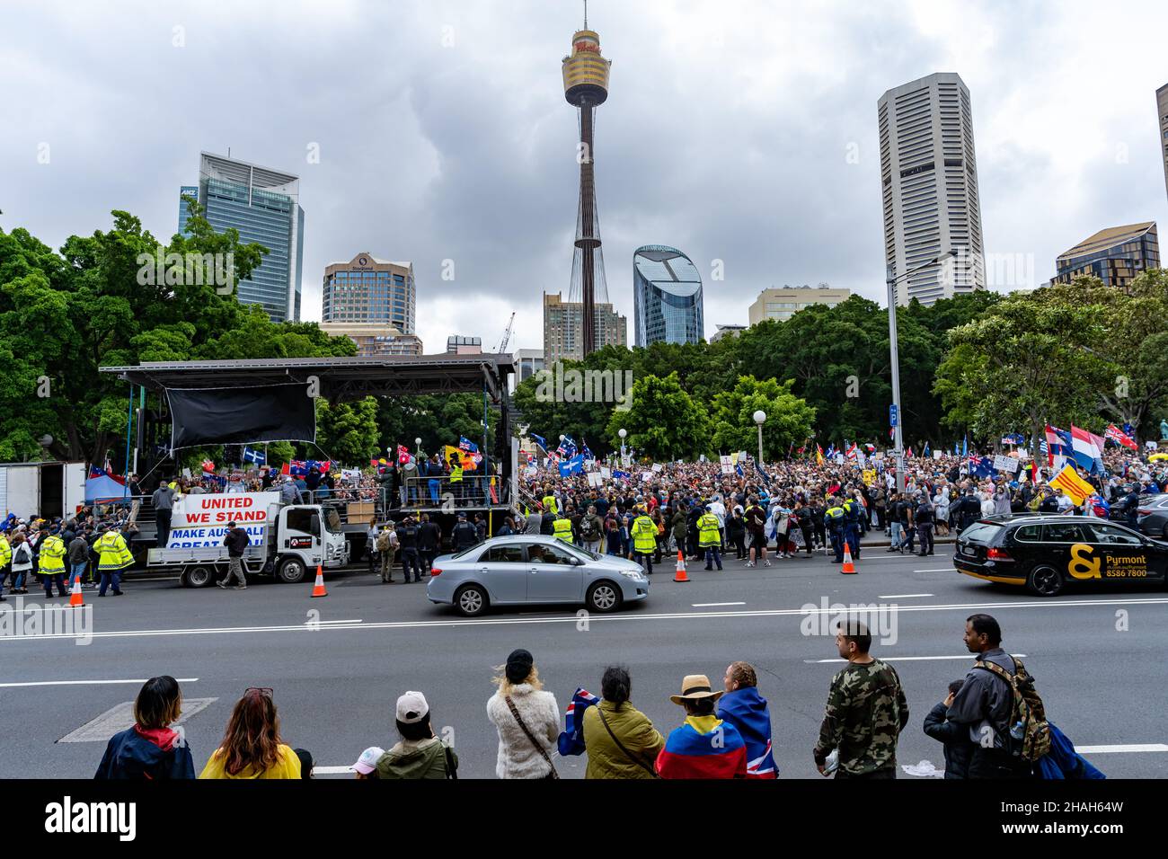Large crowd of protesters against No Jab No Job policy of Australian government. In view are Sydney Eye Tower, buildings, road, cars and police force. Stock Photo