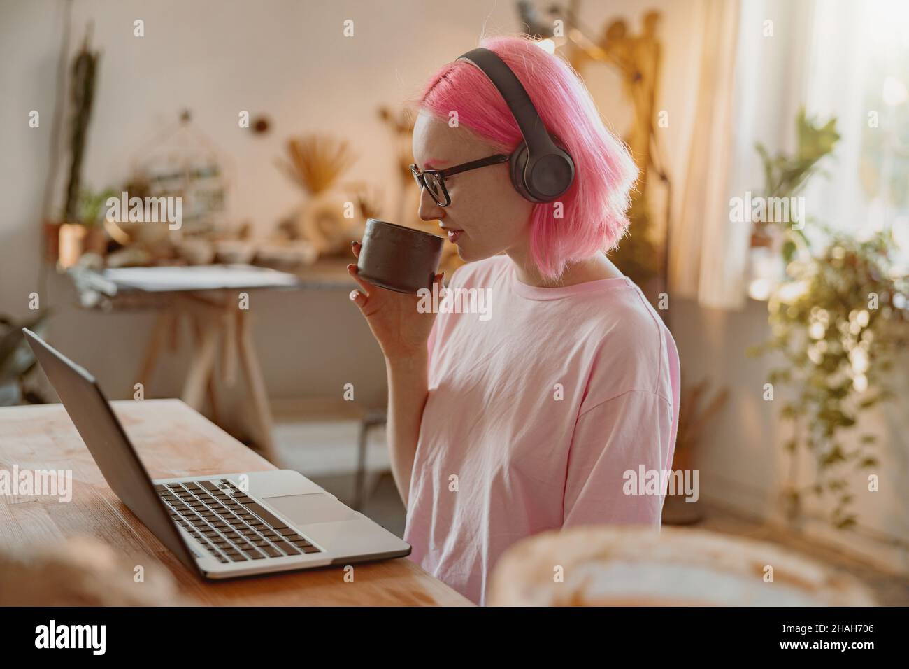Female potter using laptop in art studio Stock Photo