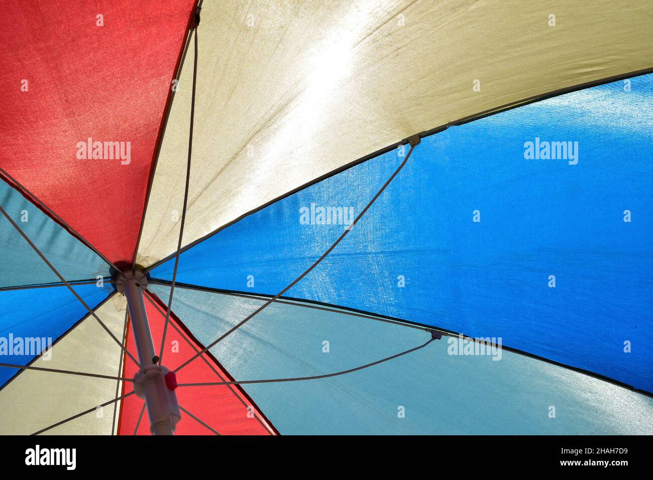 Colorful striped beach umbrella photographed from below in full frame ...