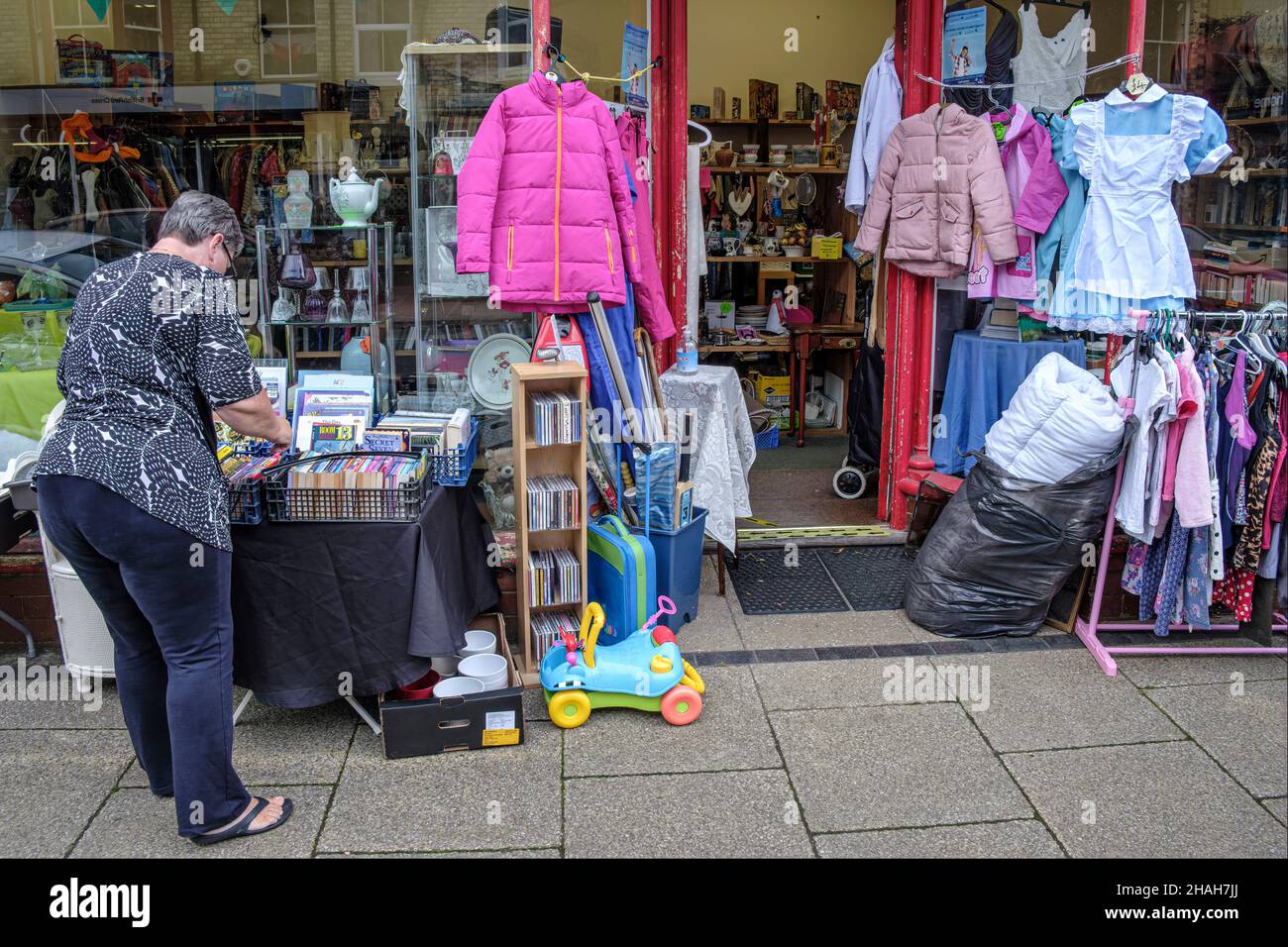 Looking for a bargain at a charity shop in Llandrindod Wells, Powys, Wales Stock Photo