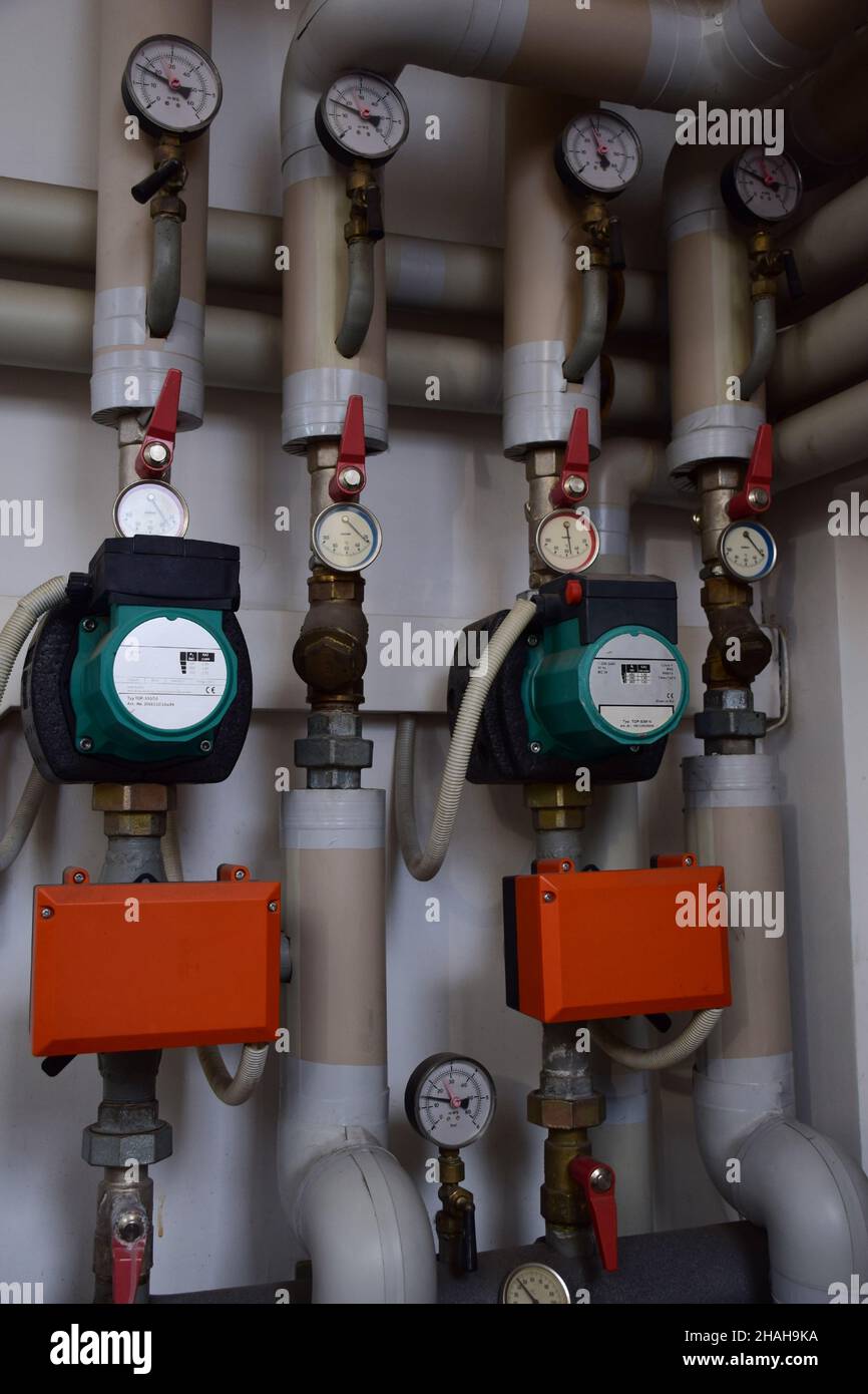 Various gas boiler pressure gauges with iron pipes emanating from them and pressure switches Stock Photo