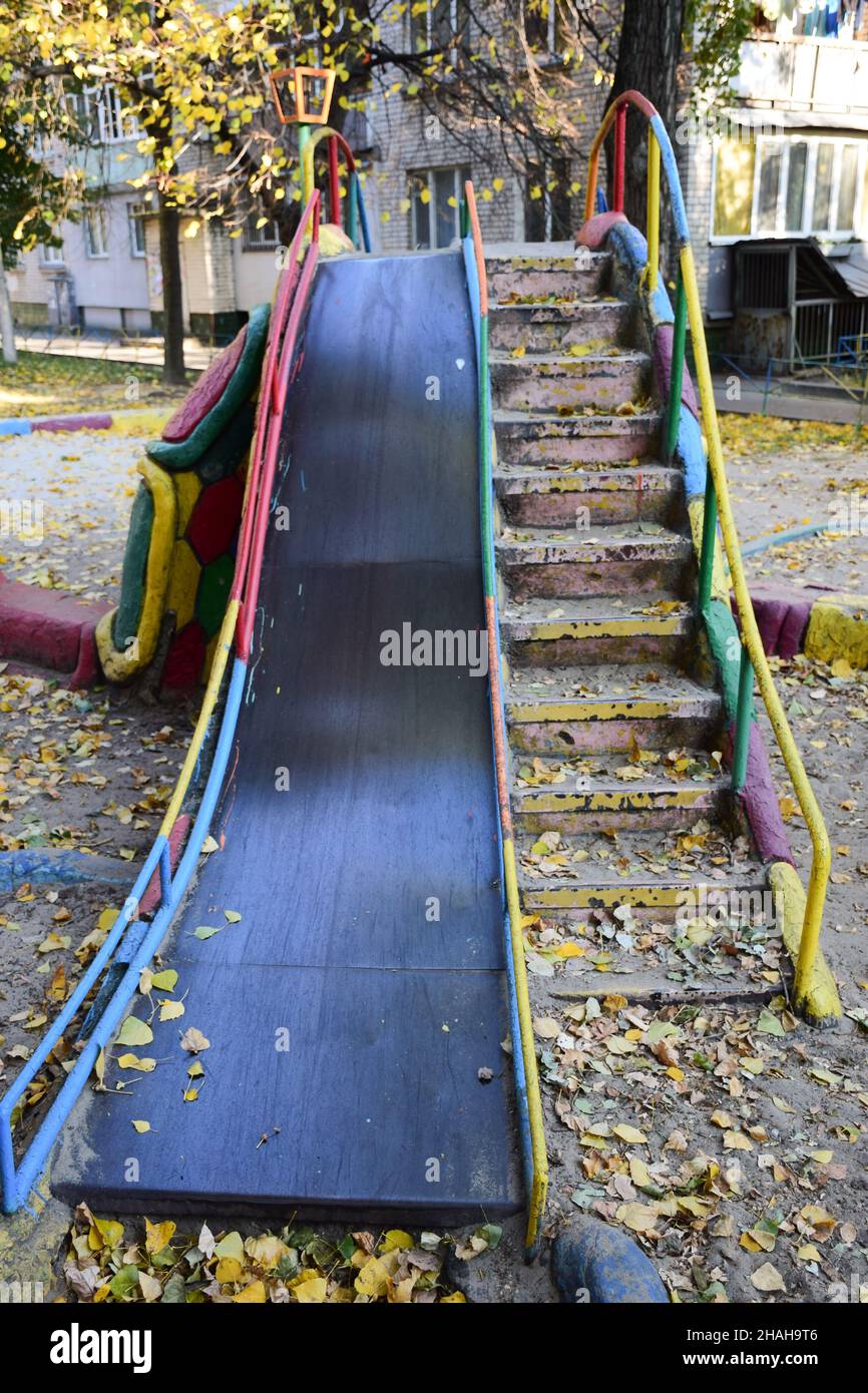 Large children's slide made of iron and concrete with a descent and a ladder. Without children, empty Stock Photo