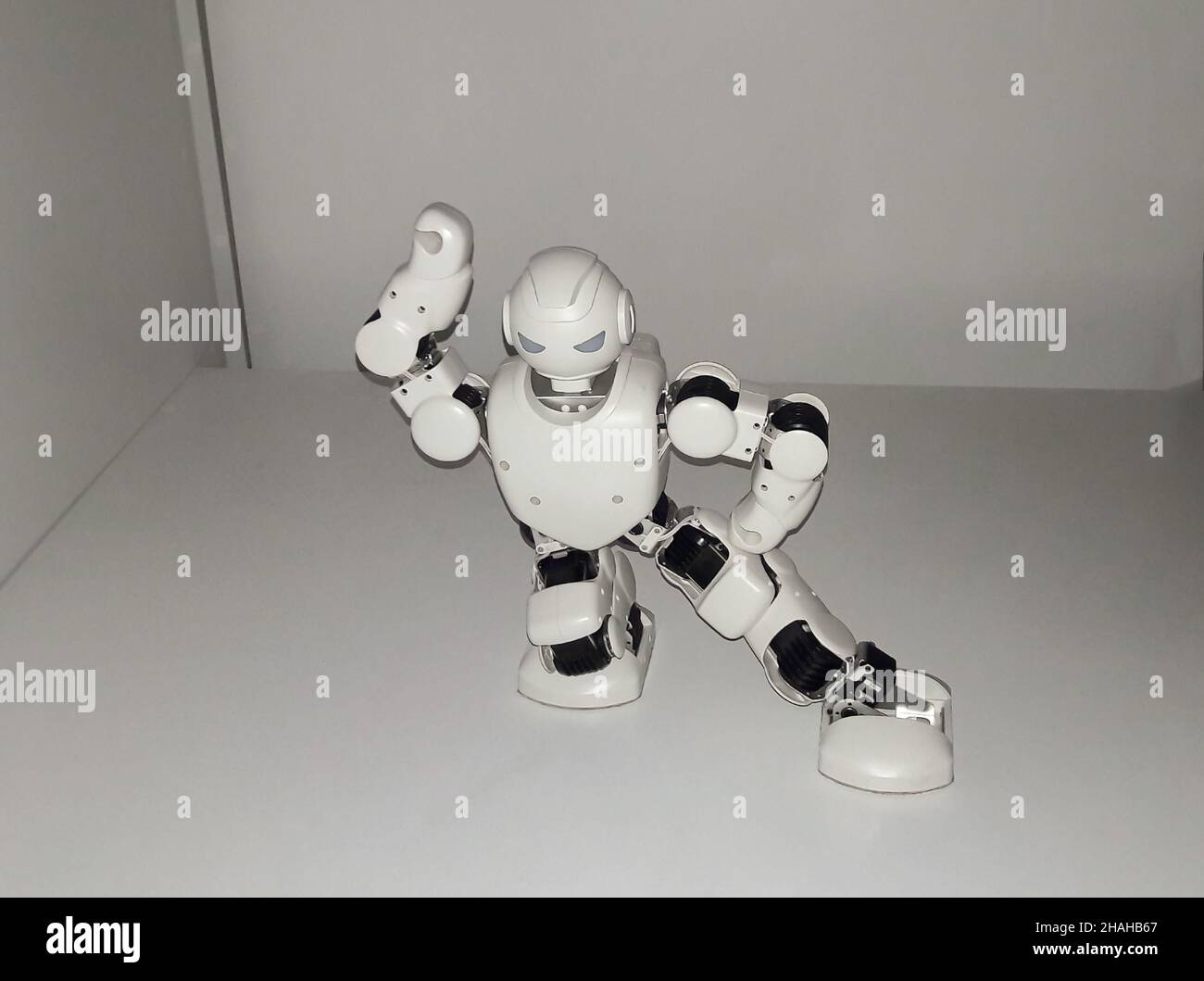 Dancing white little humanoid smart robot raised up his hand Stock Photo