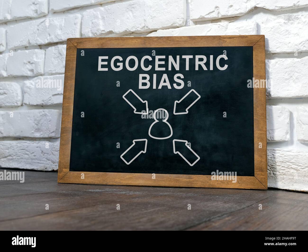 Board near wall with words Egocentric bias. Stock Photo