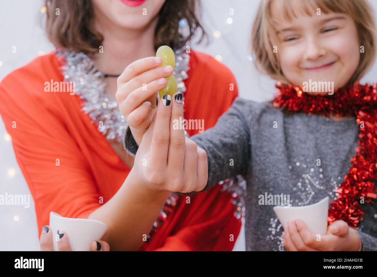 Sisters laughing and Celebrating New Year eating de twelve grapes