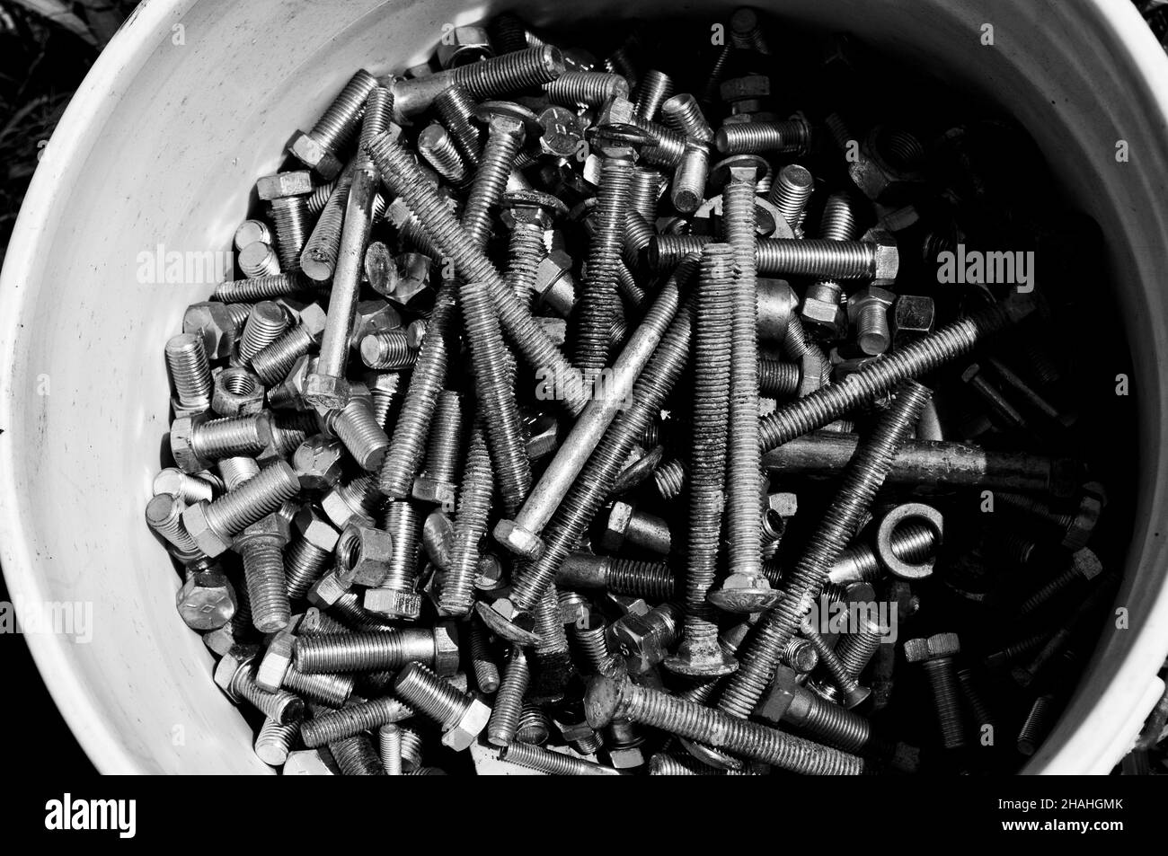 Greyscale shot of an old bucket of bolts and screws Stock Photo Alamy