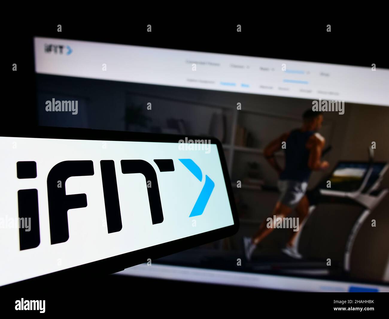 Mobile phone with logo of American fitness company iFIT Inc. on screen in front of business website. Focus on center of phone display. Stock Photo