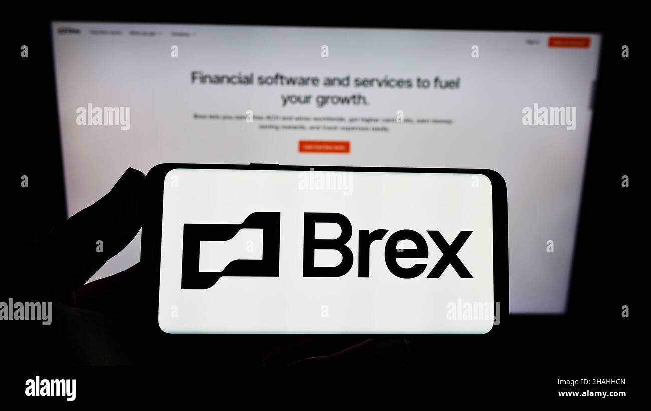 Person holding smartphone with logo of US financial technology company Brex Inc. on screen in front of website. Focus on phone display. Stock Photo