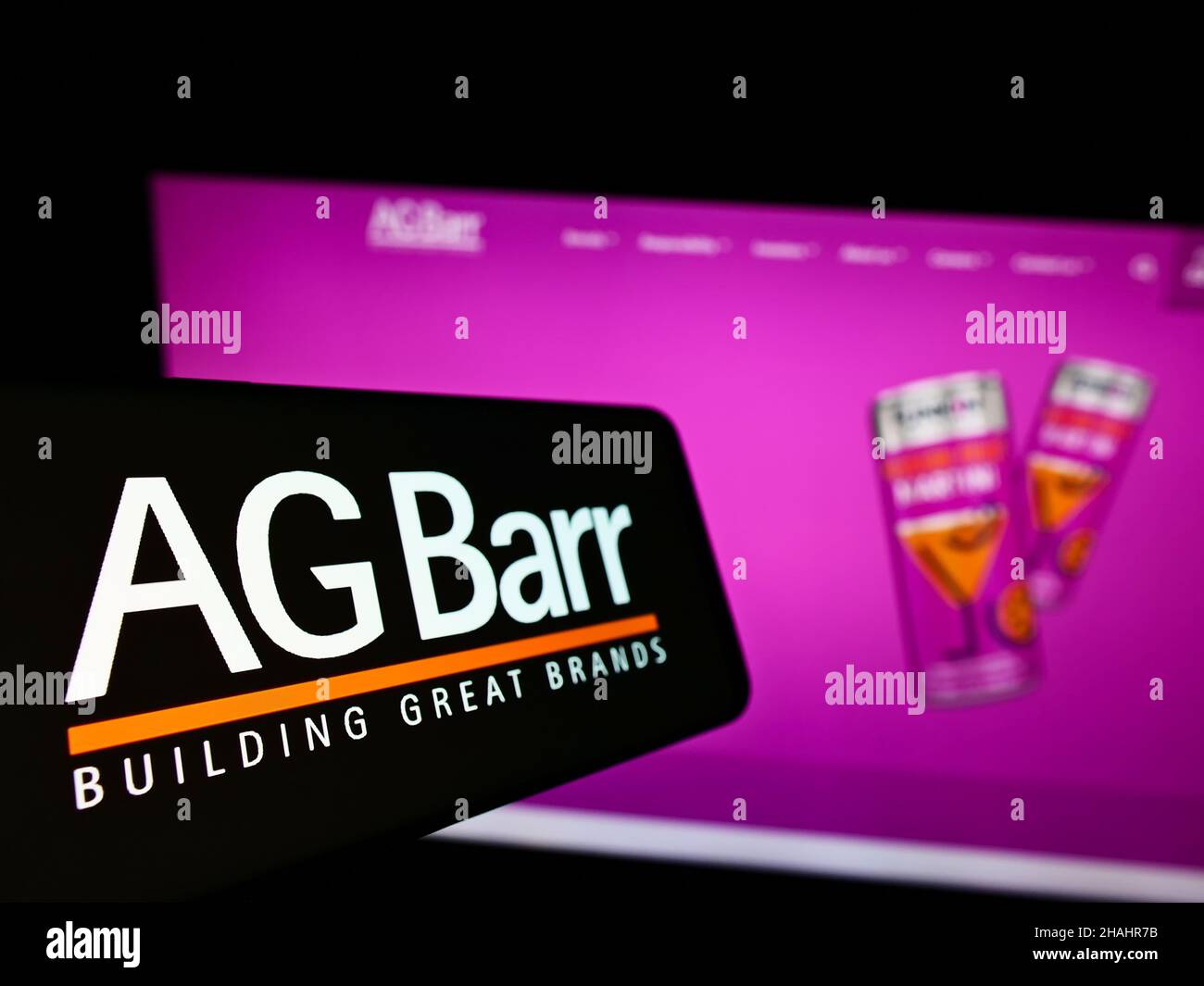 Smartphone with logo of British soft drink company A.G. Barr plc on screen in front of business website. Focus on left of phone display. Stock Photo