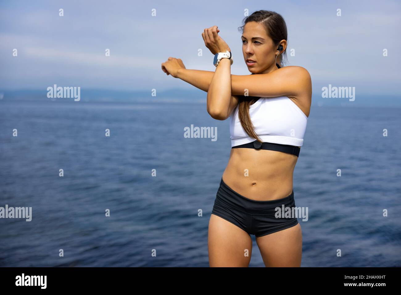 Fit Woman Looking Away While Doing Warm Up Exercise Stock Photo