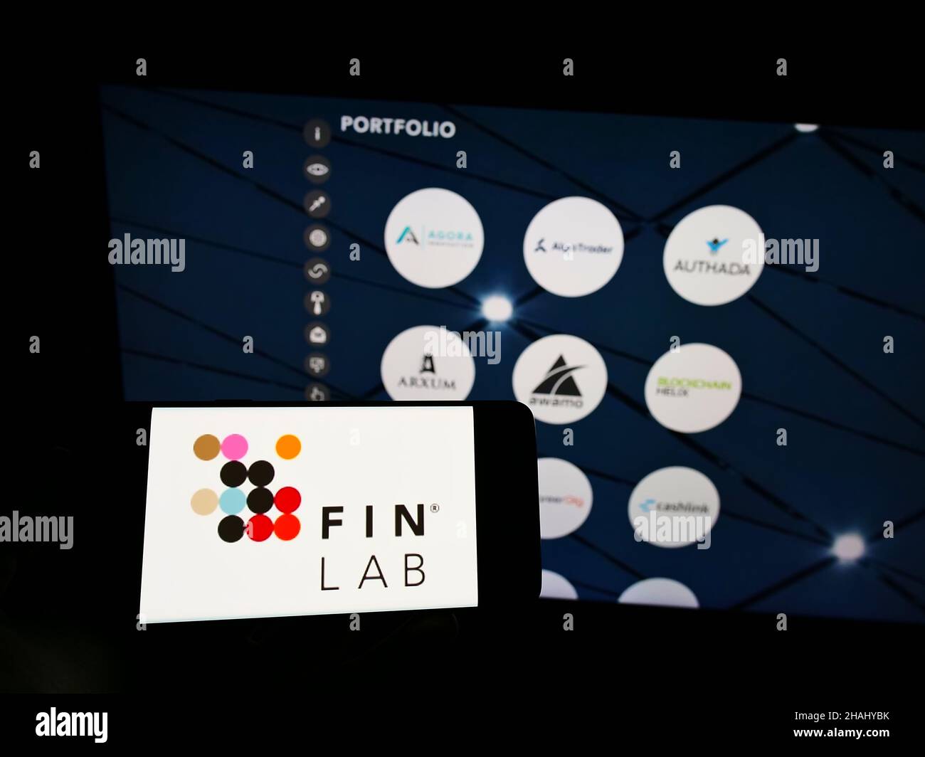 Person holding cellphone with logo of German investment company FinLab ...