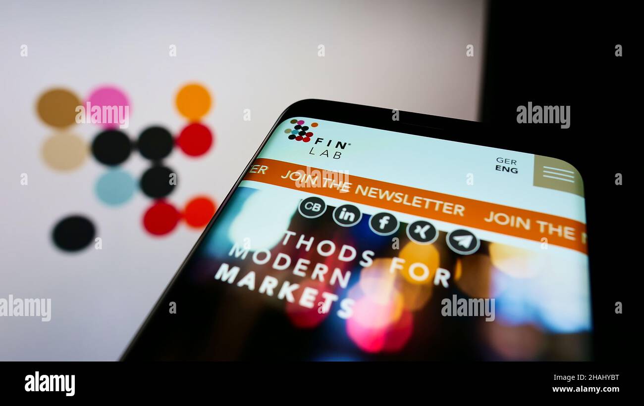 Mobile phone with website of German investment company FinLab AG on screen in front of business