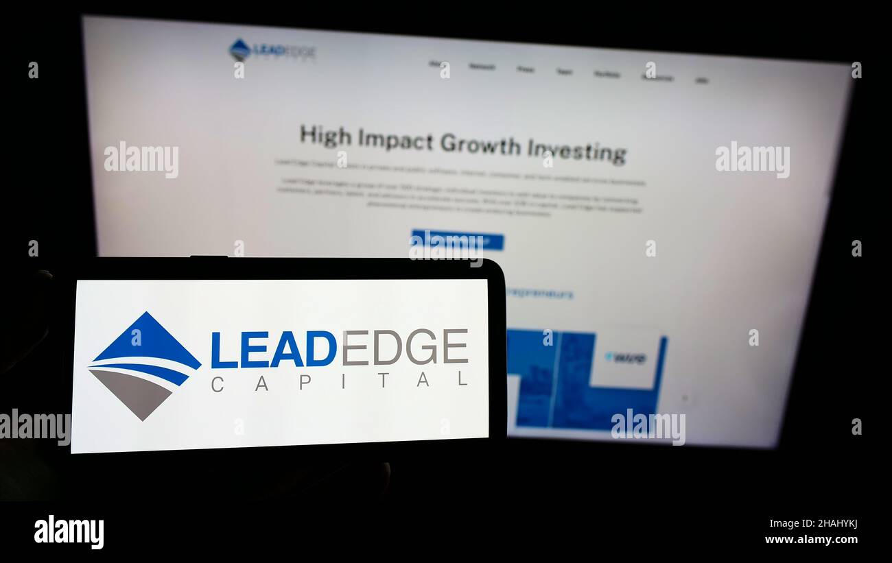 Person holding mobile phone with logo of US investment firm Lead Edge