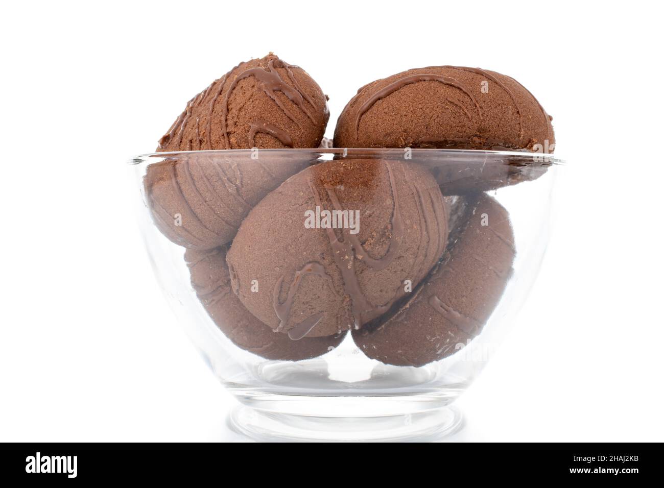Several sweet chocolate cookies in a glass dish, close-up, isolated on white. Stock Photo