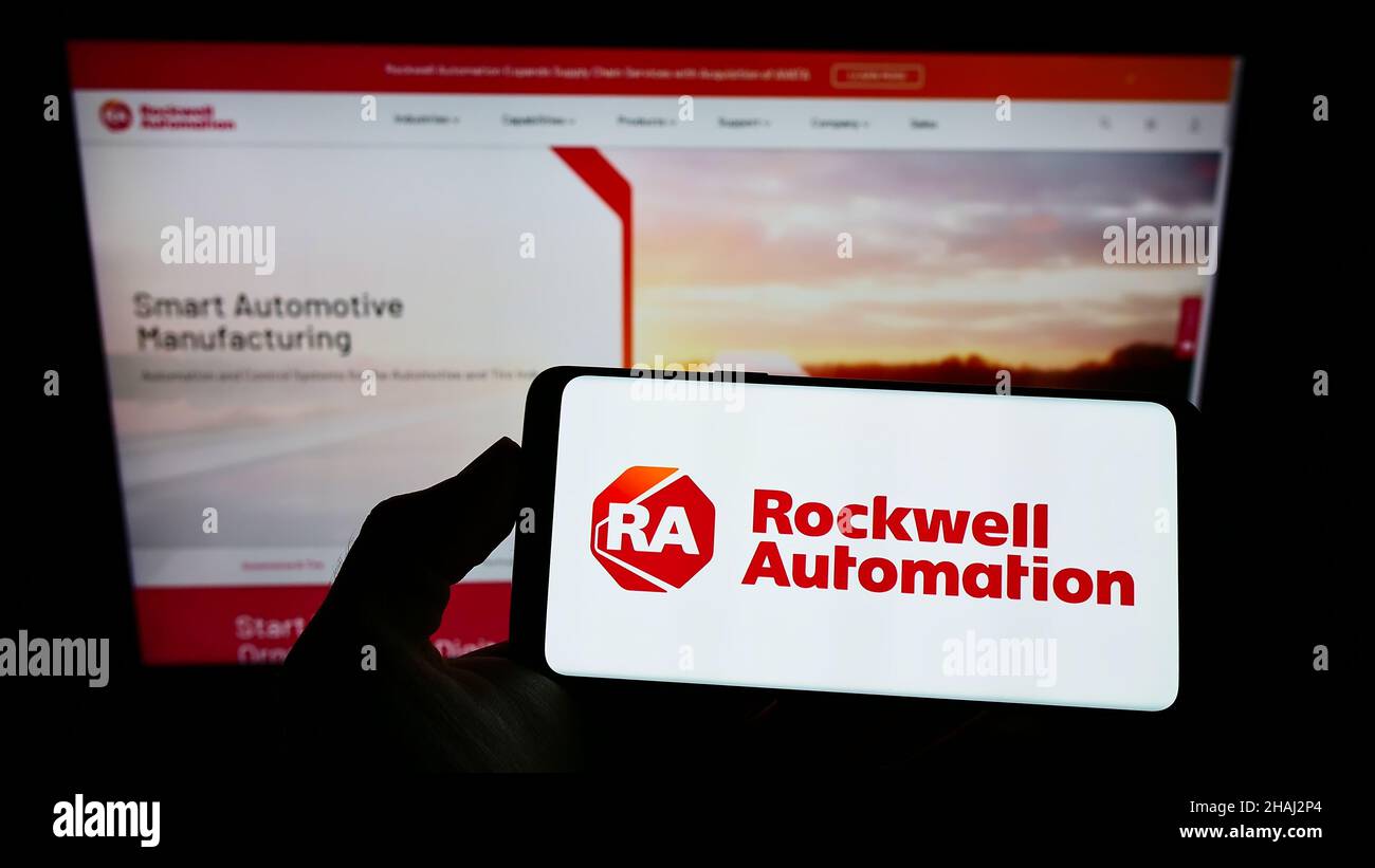 Person holding smartphone with logo of US company Rockwell Automation Inc. on screen in front of website. Focus on phone display. Stock Photo