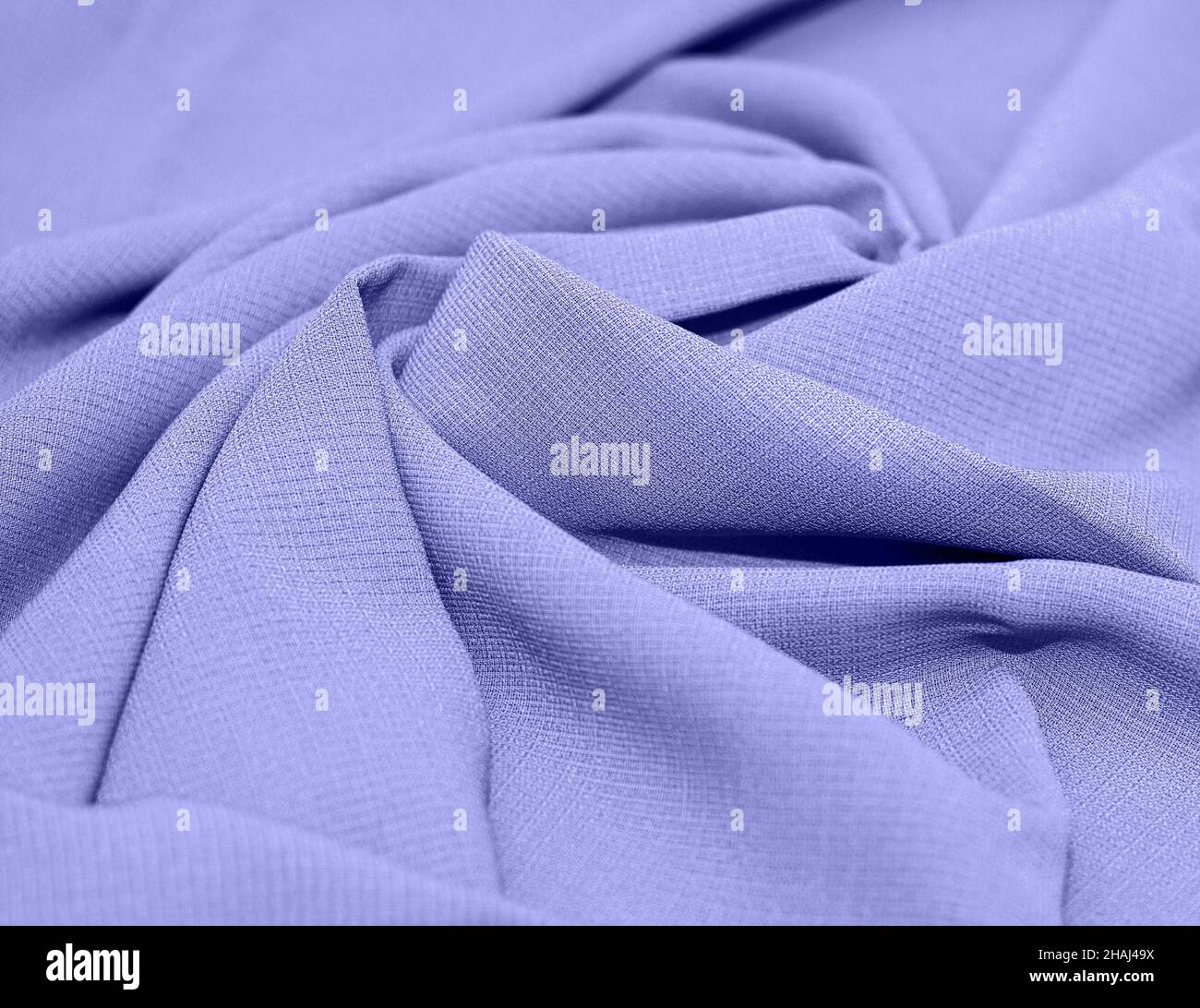 Linen, cotton pleated. Abstract textile background. The color of 2022 is Very Peri. Concept, sewing, tailor shop. Stock Photo