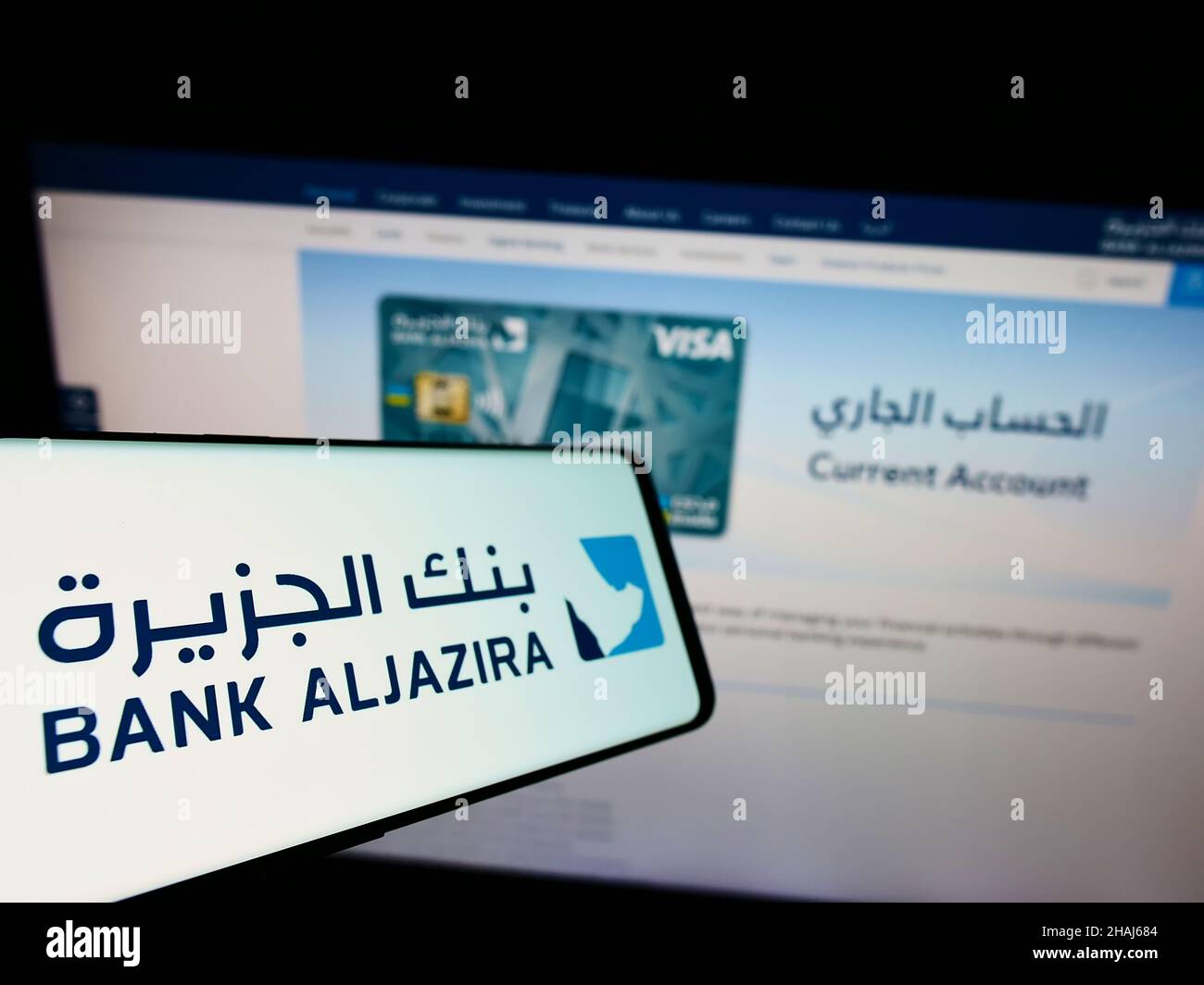 Smartphone with logo of Saudi Arabian company Bank Aljazira (BAJ) on screen in front of business website. Focus on center-left of phone display. Stock Photo