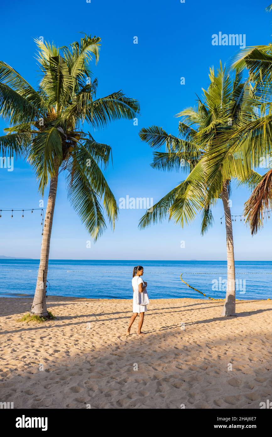 Na Jomtien Beach Pattaya Thailand, white tropical beach during sunset in Pattaya Najomtien. Asian woman walking at the beach with palm trees, tropical beach Stock Photo