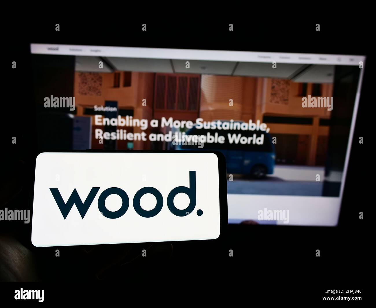 Person holding cellphone with logo of British engineering company John