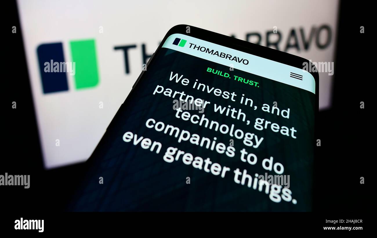 Mobile phone with website of American private equity company Thoma Bravo L.P. on screen in front of logo. Focus on top-left of phone display. Stock Photo