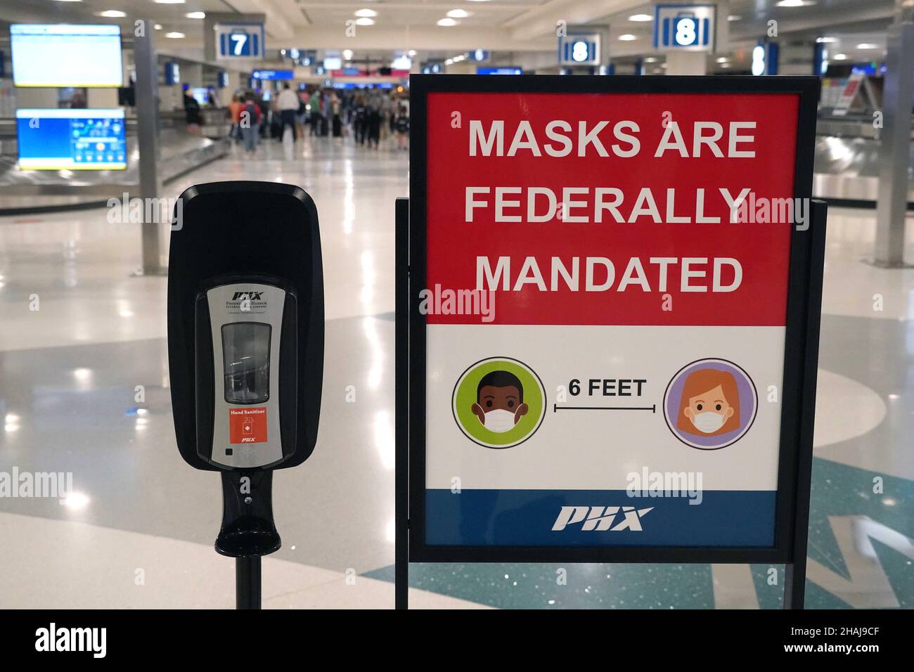A Federal mask mandate advisory sign and hand sanitizer dispenser in
