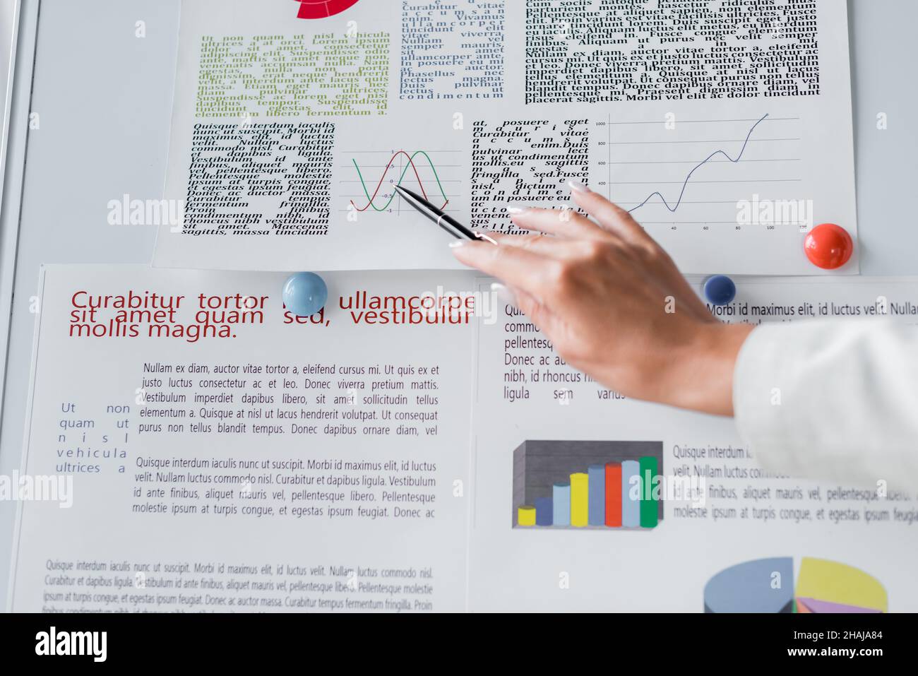 cropped view of businesswoman pointing at graphs on flip chart near