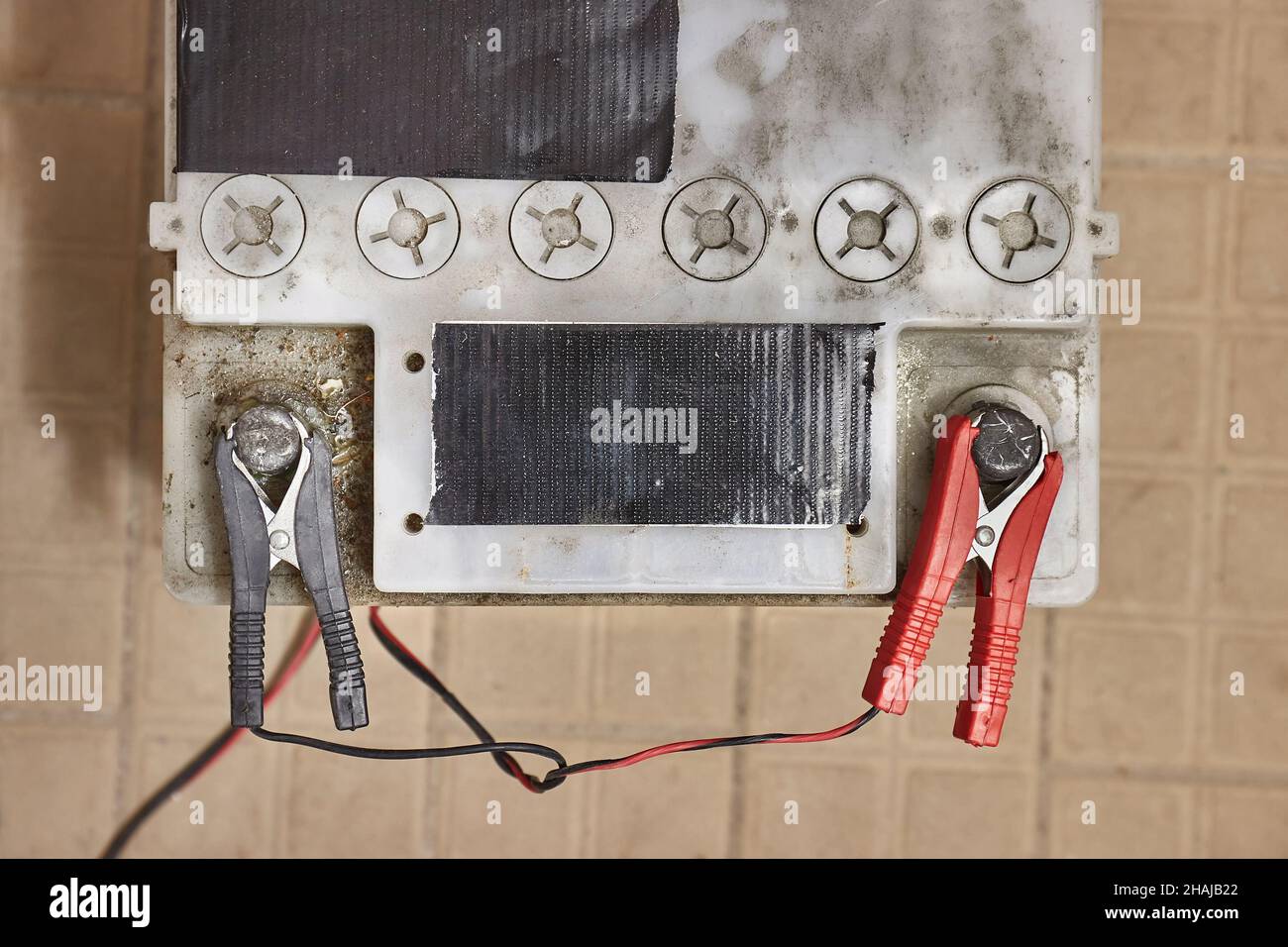 Charging a car starter battery in a garage Stock Photo