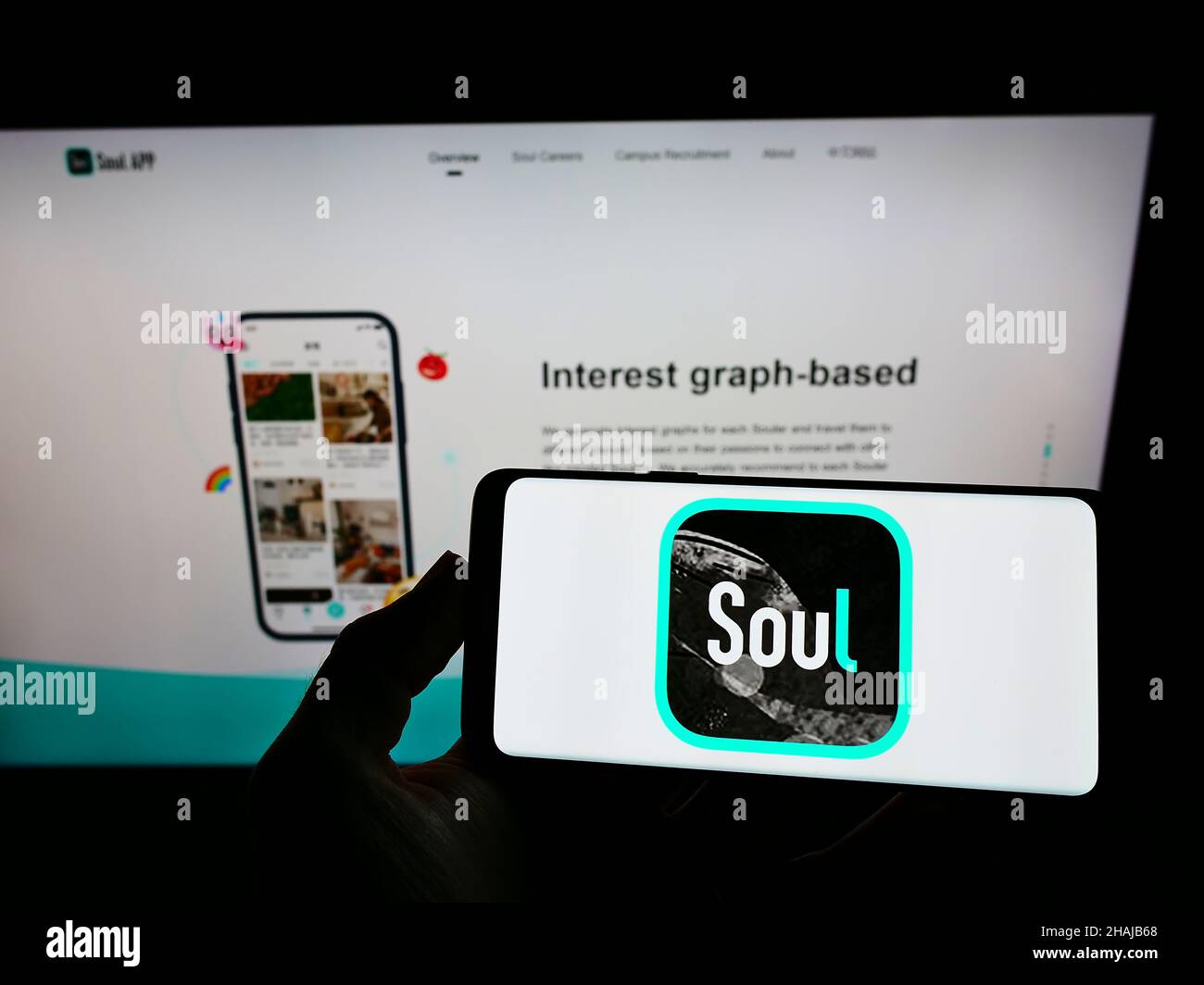Person holding smartphone with logo of Chinese social network company Soulgate Inc. (Soul) on screen in front of website. Focus on phone display. Stock Photo