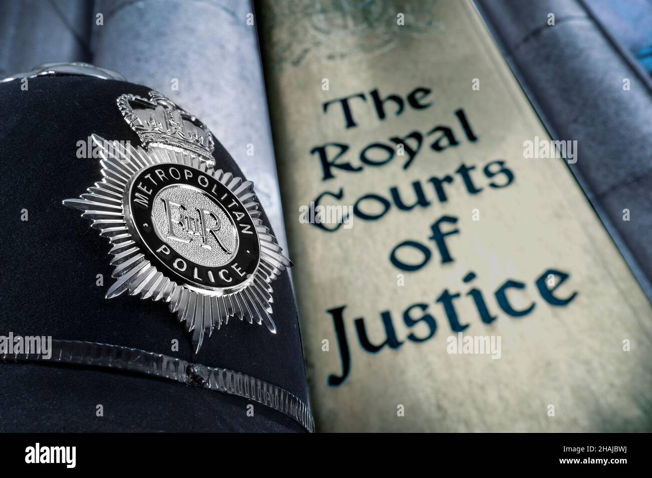 ROYAL COURTS OF JUSTICE POLICE HELMET BADGE LAW Metropolitan London Policeman, upholding The Law concept with Police helmet badge and entrance sign to Royal Courts of Justice Holborn London UK Stock Photo