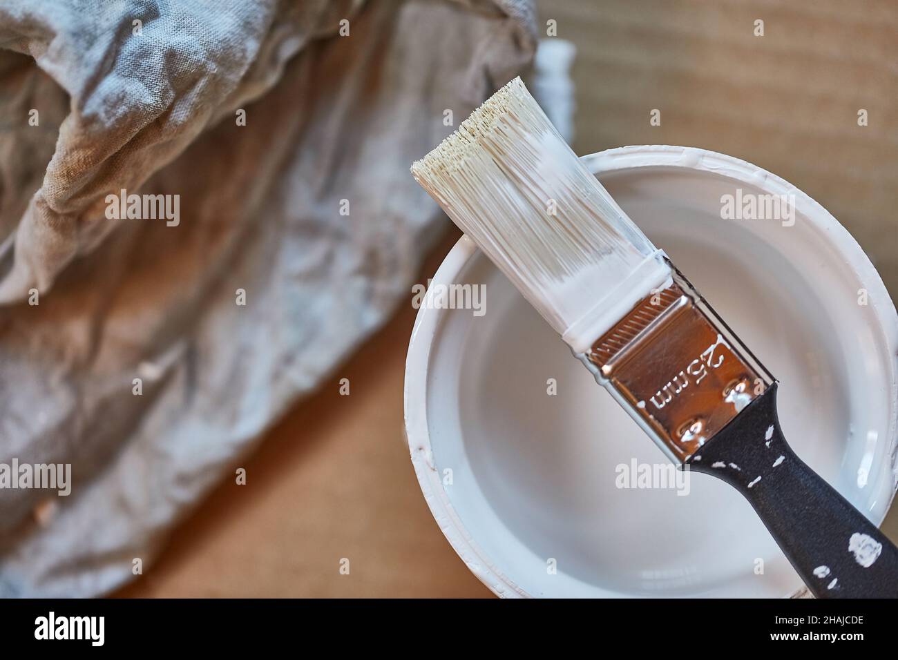 Paint brush on a can of white wall paint Stock Photo - Alamy
