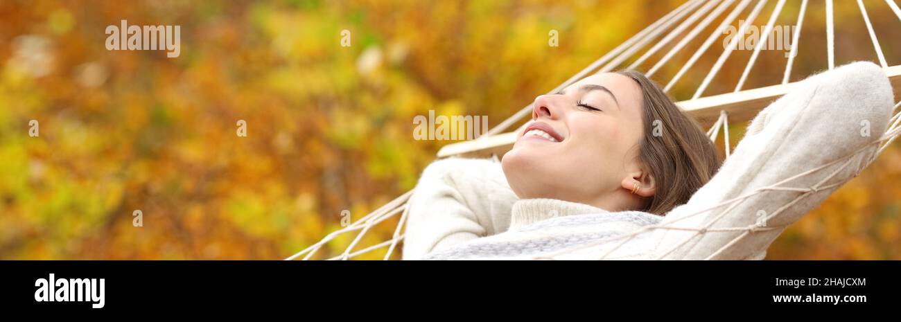 Horizontal banner of a happy woman relaxing lying on hammock in autumn Stock Photo