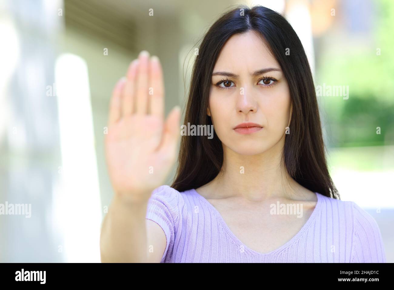 Front view portrait of an asian woman gesturing stop in the street Stock Photo